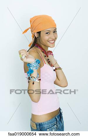 Teen girl wearing lots of accessories, hands up, smiling at camera, portrait View Large Photo Image Picture - Teen girl wearing lots of accessories, hands up, smiling at camera, portrait. Fotosearch