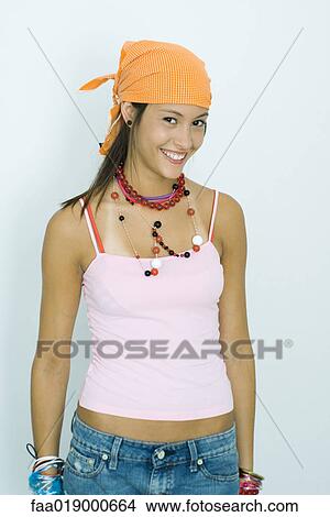 Picture - Teen girl wearing lots of accessories, smiling at camera, portrait. Fotosearch