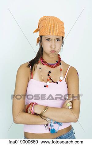 Teen girl wearing lots of accessories, arms folded, blowing cheeks out, portrait View Large Photo Image Stock Image - Teen girl wearing lots of accessories, arms folded, blowing cheeks out, portrait. Fotosearch
