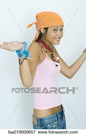 Stock Photo - Teen girl wearing lots of accessories, hands out, smiling at camera, portrait. Fotosearch
