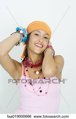 Teen girl wearing lots of accessories, hands behind head, smiling at camera, portrait View Large Photo Image Stock Photograph - Teen girl wearing lots of accessories, hands behind head, smiling at camera, portrait. Fotosearch