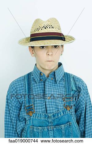 Teen girl wearing overalls and cap, making face, portrait View Large Photo Image Picture - Teen girl wearing overalls and cap, making face, portrait. Fotosearch