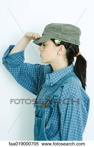 Teen girl wearing overalls and cap, saluting, portrait View Large Photo Image Stock Photography - Teen girl wearing overalls and cap, saluting, portrait. Fotosearch