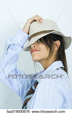 Teen girl wearing shirt, tie and hat, peeking at camera View Large Photo Image Stock Photograph - Teen girl wearing shirt, tie and hat, peeking at camera. Fotosearch