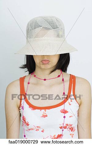 Teen girl wearing sun hat, eyes covered and pouting, portrait View Large Photo Image Stock Photo - Teen girl wearing sun hat, eyes covered and pouting, portrait. Fotosearch