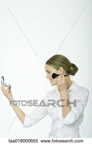 Stock Photography - Teenage girl applying blush. Fotosearch