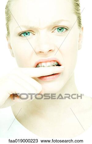 Teenage girl biting finger, close-up View Large Photo Image Stock Image - Teenage girl biting finger, close-up. Fotosearch