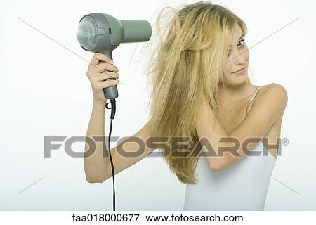 Teenage girl blow-drying hair View Large Photo Image Stock Photo - Teenage girl blow-drying hair. Fotosearch