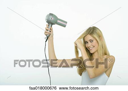 Teenage girl blow-drying hair View Large Photo Image Stock Photograph - Teenage girl blow-drying hair. Fotosearch
