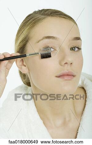 Teenage girl brushing eyelashes View Large Photo Image Stock Photo - Teenage girl brushing eyelashes. Fotosearch