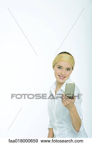 Stock Photo - Teenage girl looking at face in hand mirror. Fotosearch