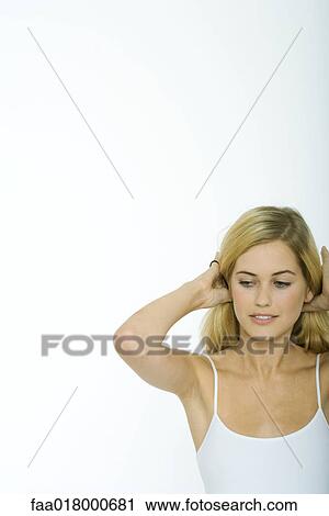 Stock Image - Teenage girl pushing hair back. Fotosearch