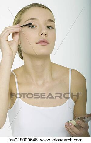 Teenage girl putting on eyeshadow View Large Photo Image Stock Photograph - Teenage girl putting on eyeshadow. Fotosearch