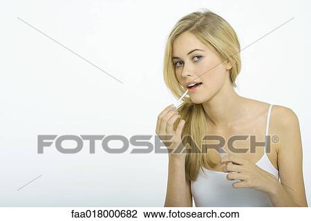 Teenage girl putting on lipgloss View Large Photo Image Stock Image - Teenage girl putting on lipgloss. Fotosearch