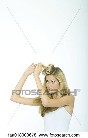 Stock Photo - Teenage girl putting rollers in hair. Fotosearch