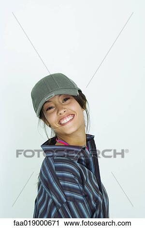 Teenage girl wearing large button down shirt and baseball cap, portrait View Large Photo Image Stock Image - Teenage girl wearing large button down shirt and baseball cap, portrait. Fotosearch