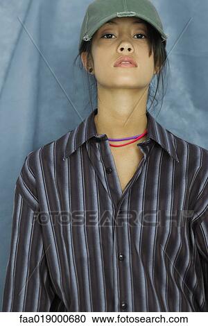 Teenage girl wearing large button down shirt and baseball cap, portrait View Large Photo Image Stock Image - Teenage girl wearing large button down shirt and baseball cap, portrait. Fotosearch