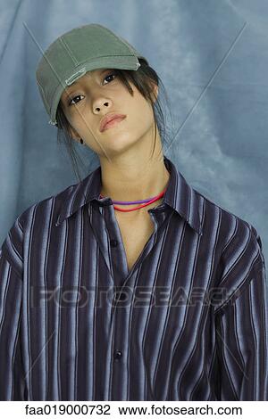 Teenage girl wearing large button down shirt and baseball cap, portrait View Large Photo Image Stock Image - Teenage girl wearing large button down shirt and baseball cap, portrait. Fotosearch