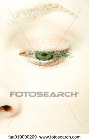 Stock Photo - Teenage girl's face, eye lowered, extreme close-up. Fotosearch