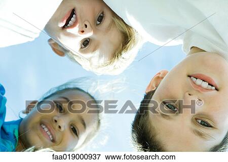 Three children, low angle view View Large Photo Image Stock Photo - Three children, low angle view. Fotosearch