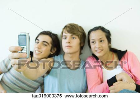 Three teen friends taking self portrait with cell phone View Large Photo Image Stock Photography - Three teen friends taking self portrait with cell phone. Fotosearch
