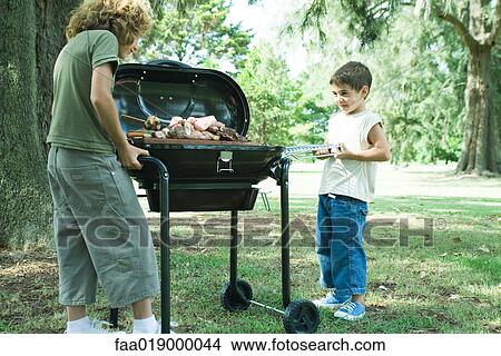 Two boys standing next tray of grilled meat on barbecue View Large Photo Image Picture - Two boys standing next tray of grilled meat on barbecue. Fotosearch