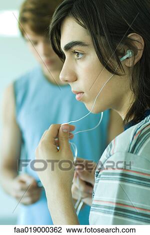 Two teen boys listening to MP3 player View Large Photo Image Stock Image - Two teen boys listening to MP3 player. Fotosearch