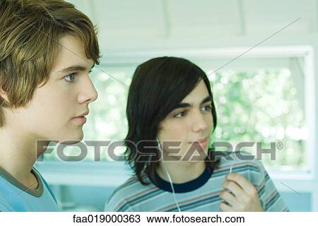 Two teen boys listening to MP3 player View Large Photo Image Stock Image - Two teen boys listening to MP3 player. Fotosearch
