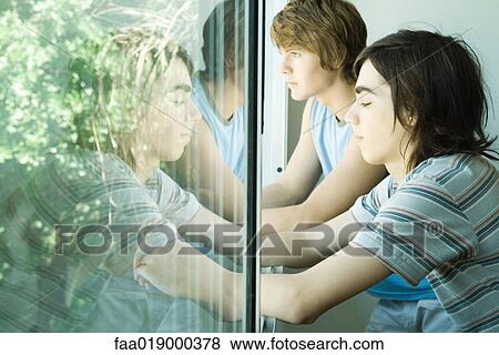Two teen boys, looking out of window View Large Photo Image Stock Photo - Two teen boys, looking out of window. Fotosearch