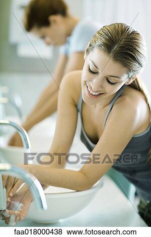 Two women washing hands in public restrooms View Large Photo Image Stock Photo - Two women washing hands in public restrooms. Fotosearch