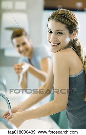 Stock Photo - Two women washing hands in public restrooms. Fotosearch