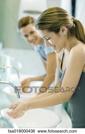 Stock Photograph - Two women washing hands in public restrooms. Fotosearch