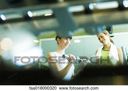 Two women working out in weight room View Large Photo Image Stock Image - Two women working out in weight room. Fotosearch