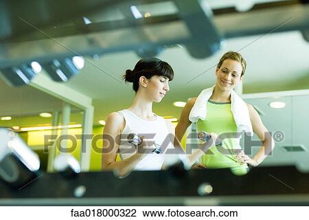 Two women working out in weight room View Large Photo Image Stock Image - Two women working out in weight room. Fotosearch
