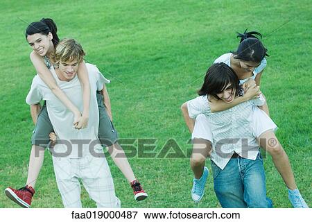 Two young couples, girlfriends being carried piggyback View Large Photo Image Stock Photo - Two young couples, girlfriends being carried piggyback. Fotosearch