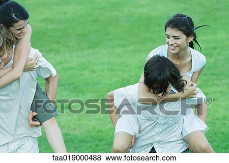 Two young couples, girlfriends being carried piggyback View Large Photo Image Stock Photo - Two young couples, girlfriends being carried piggyback. Fotosearch