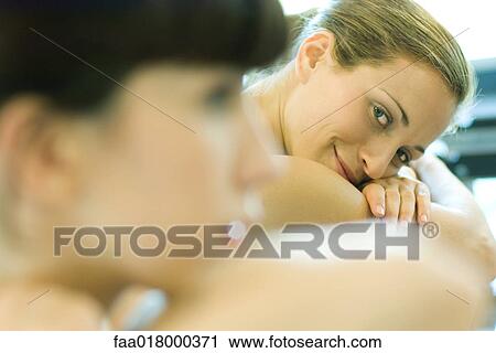 Two young women, focus on woman in background resting head on arms View Large Photo Image Stock Image - Two young women, focus on woman in background resting head on arms. Fotosearch