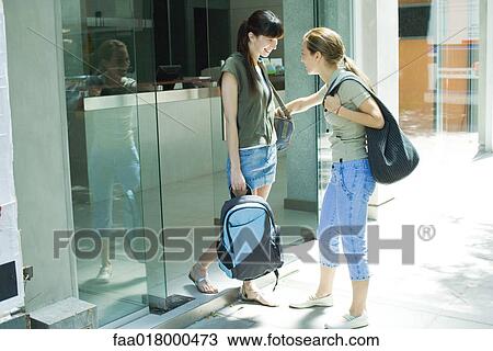 Two young women standing in doorway, talking View Large Photo Image Stock Image - Two young women standing in doorway, talking. Fotosearch