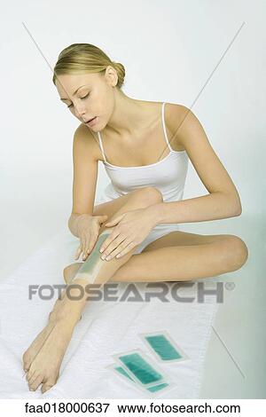 Stock Photo - Woman applying cold wax strips. Fotosearch