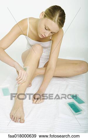 Stock Photo - Woman applying cold wax strips. Fotosearch