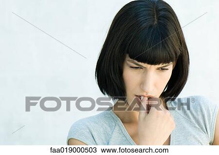 Stock Image - Woman, biting fingers, portrait. Fotosearch