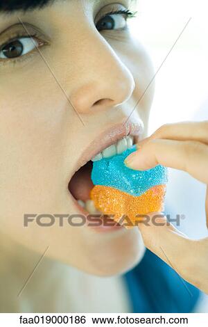 Stock Photograph - Woman biting into candy, close-up. Fotosearch