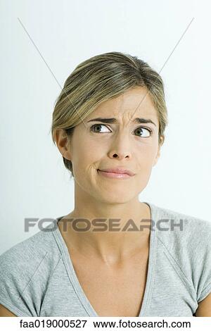Stock Photo - Woman, furrowing brow, looking away, portrait. Fotosearch
