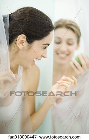 Stock Photo - Woman handing friend soap in public showers. Fotosearch