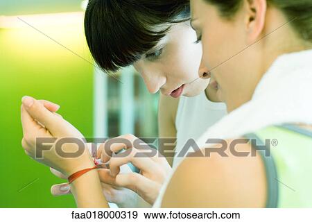 Woman helping friend remove bracelet View Large Photo Image Stock Photo - Woman helping friend remove bracelet. Fotosearch