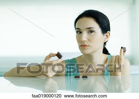 Woman holding up pieces of chocolate View Large Photo Image Stock Image - Woman holding up pieces of chocolate. Fotosearch