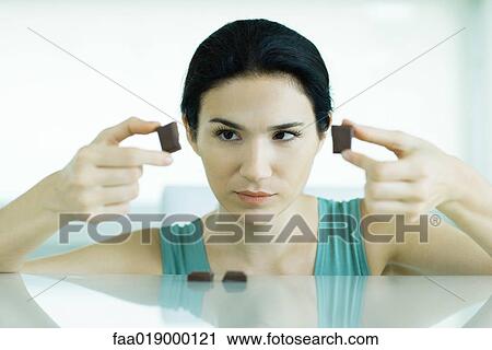 Woman holding up pieces of chocolate View Large Photo Image Stock Image - Woman holding up pieces of chocolate. Fotosearch