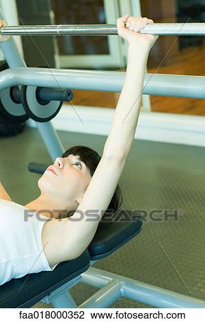 Stock Image - Woman lifting barbell. Fotosearch
