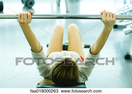 Stock Image - Woman lifting weights. Fotosearch