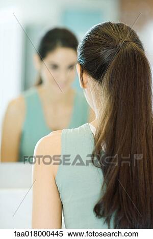 Woman looking at self in mirror, rear view View Large Photo Image Stock Photography - Woman looking at self in mirror, rear view. Fotosearch